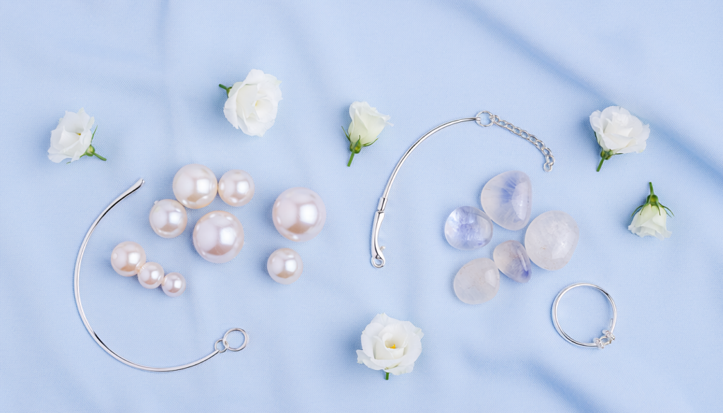 Pearl gemstone and moonstone crystals on light blue fabric representing lucky stone for number 2 in numerology